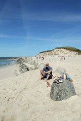 Hoernum  Deutschland  Besucher ruhen sich an Tetrapoden am Strand von Hoernum auf Sylt aus