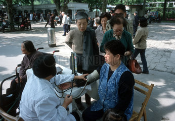 Rentner beim Blutdruckmessen im Fuxing Park in Shanghai