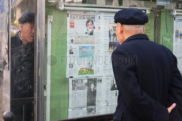 Peking  ein alter Mann liest eine Tageszeitung im Aushang