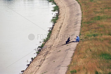 Mann mit seinem Hund an der Warthe in Poznan  Polen
