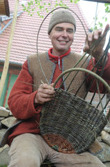 Buetzow  Deutschland  ein Korbflechter flicht Weidenruten beim Klosterfest