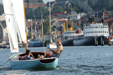 Flensburg  Deutschland  Maenner mit einem kleinen Segelboot im Flensburger Hafen