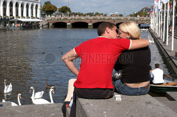 Hamburg  ein junges Paar sitzt am Alsterfleet
