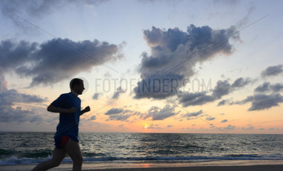 Hvide Sande  Daenemark  Mann joggt am Strand