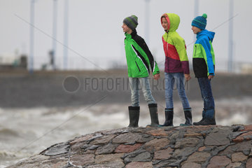 Dagebuell  Deutschland  Kinder stehen auf dem Deich und stemmen sich gegen den Wind