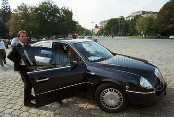 Fahrer und Bodyguard einer Persoenlichkeit warten bei deren Limousine  Sofia