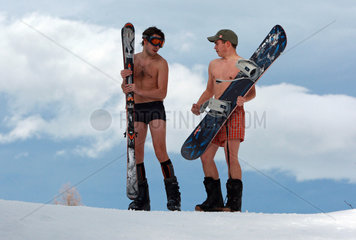 Krippenbrunn  Oesterreich  junge Maenner in Boxershorts mit Snowboard und Skier