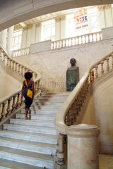 Havanna  Kuba  eine Besucherin auf der Freitreppe des Museo de la Revolucion  auf dem Podest die Bueste von Jose Marti