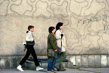 Drei Frauen gehen an einer Mauer entlang  Kaliningrad  Russland