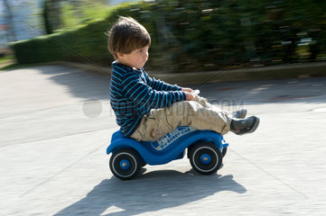 Carabietta  Schweiz  Junge faehrt mit einem Bobby Car
