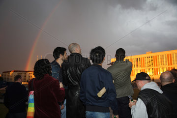 Berlin  Deutschland  Menschen schauen sich einen Regenbogen an