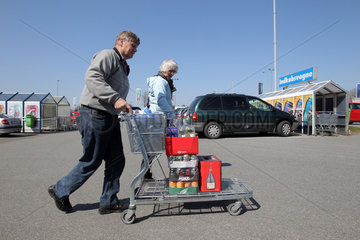 Harrislee  Deutschland  daenisches Ehepaar mit Einkaufswagen voller Getraenke