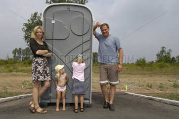 Deutschland  eine Familie steht auf der Baustelle ihres Einfamilienhauses