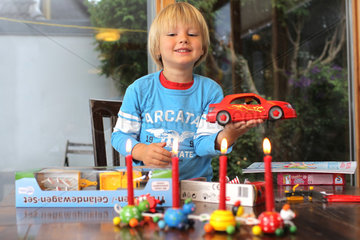 Harrislee  Deutschland  Junge packt zu seinem vierten Geburtstag Geschenke aus