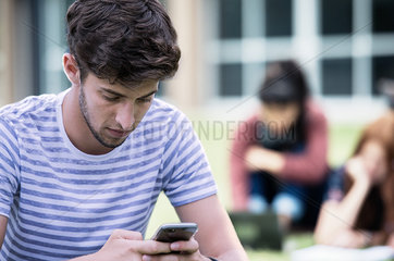 Young man looking at smartphone outdoors
