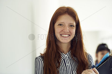 Female student smiling in corridor  portrait