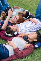 Group of friends lying on grass relaxing together