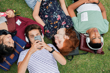 College friends relaxing on grass together