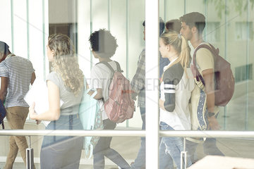 Students walking in school corridor  viewed through window