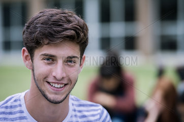 Young man smiling cheerfully outdoors  portrait