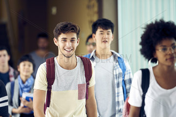 Student smiling as he walks between classes