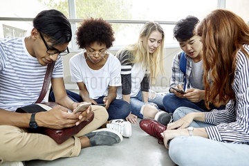 Students sitting together using smart phones