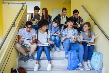 Group of college students studying on stairs