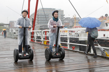 Kiel  Deutschland  zwei Frauen fahren bei starkem Regen auf Segways