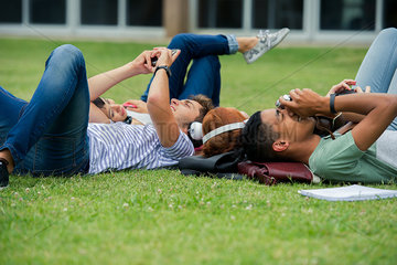 College students relaxing together on lawn between classes