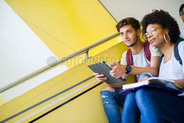 College students sitting in stairwell