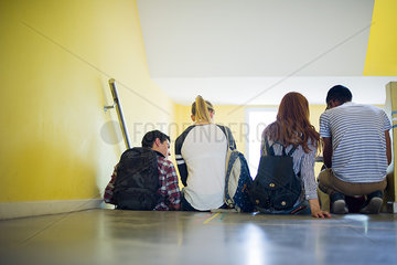 Students sitting together in stairwell  rear view