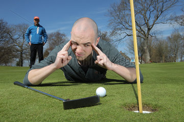 Gluecksburg  Deutschland  Golfanfaenger mit Golflehrer auf dem Uebungsplatz beim Putten