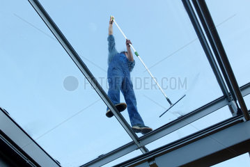 Ein Fensterputzer (nicht erkennbar) saeubert ein Glasdach  Duisburg