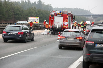 Allersberg  Deutschland  Feuerwehrmaenner beseitigen nach einem Autounfall auf der A9 eine Oelspur