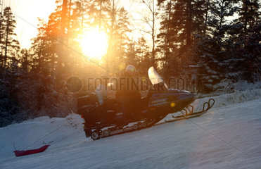 Ingatorp  Schweden  Maenner auf einem Schneemobil