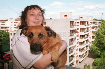 Frau mit Hund auf Hochhaus-Balkon  Berlin