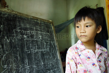 Vietnam  Junge im Portrait vor einer Schiefertafel