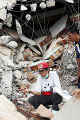 Padang  Indonesien  ein verzweifelter Mann sitzt inmitten der Truemmer seines Hauses
