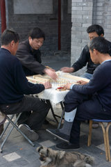 Peking  vier Maenner spielen Brettspiel
