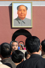 Peking  aelteres Ehepaar wird vor Mao-Portaet fotografiert