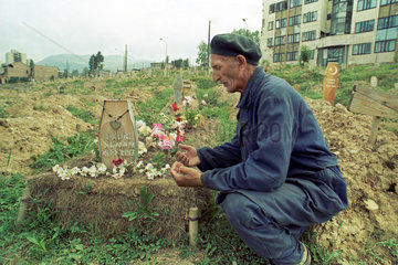 Sarajevo  Bosnien und Herzegowina  Mann trauert an einem Grab in der Innenstadt