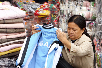 Eine Kundin am Cho Dong Xuan Markt begutachtet eine Trainingsjacke