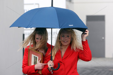 Hannover  Deutschland  Frauen laufen gemeinsam unter einem Regenschirm