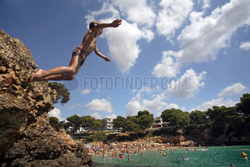 Cala D'Or  Jugendlicher springt von einem Felsen ins Wasser