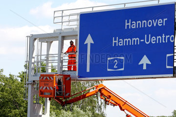 Werne  Deutschland  Arbeiter montieren ein Schild auf der A2