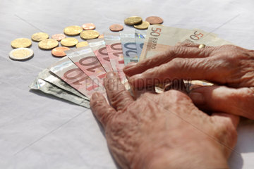 Berlin  Deutschland  die Haende einer Rentnerin liegen auf Geld