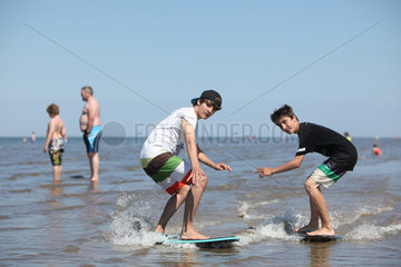 Sankt Peter-Ording  Deutschland  zwei Jugendliche auf Skimboards am Strand