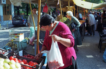 Frau kauft Tomaten auf einem Obst- und Gemuesemarkt in Plovdiv  Bulgarien