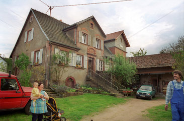 Zugezogene deutsche Familie vor ihrem Hof im Elsass