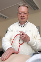 Bad Segeberg  Deutschland  Dr. Uwe Denker untersucht einen Patienten in seiner Praxis ohne Grenzen